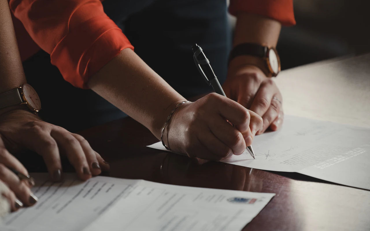 People signing documents.
